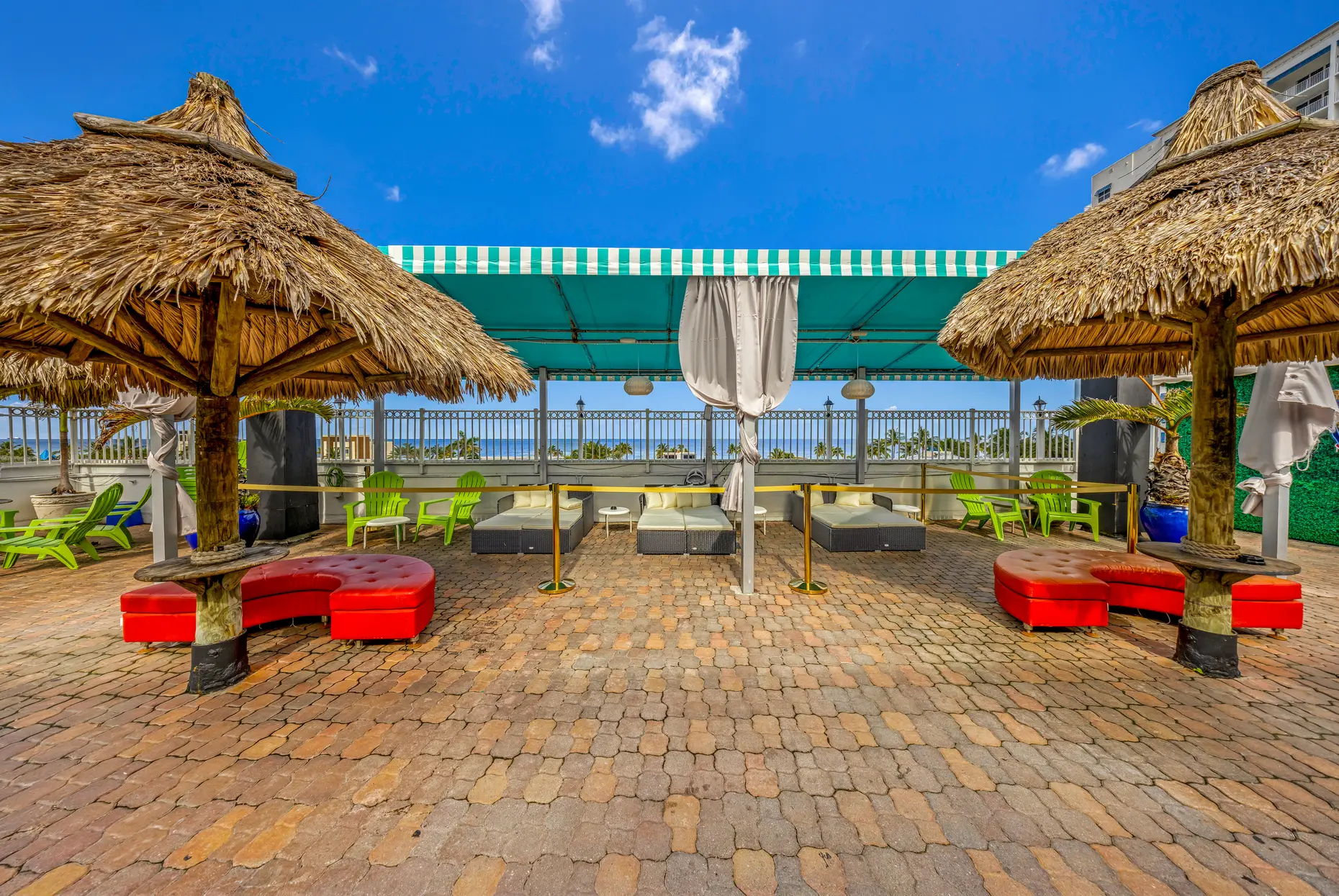Palapa lounge with red sofas and an ocean view