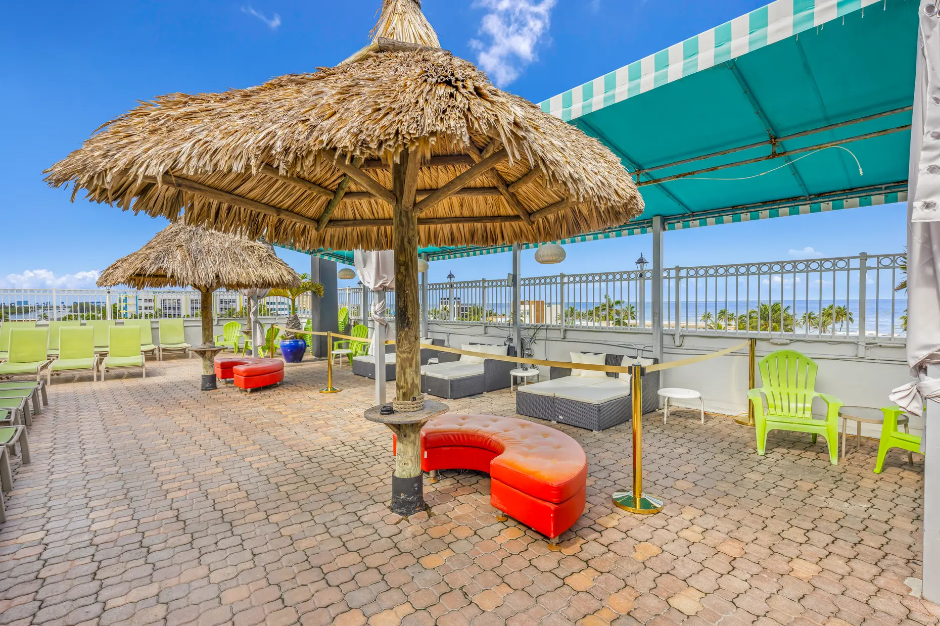 Cabana lounge with red sofas on the rooftop deck