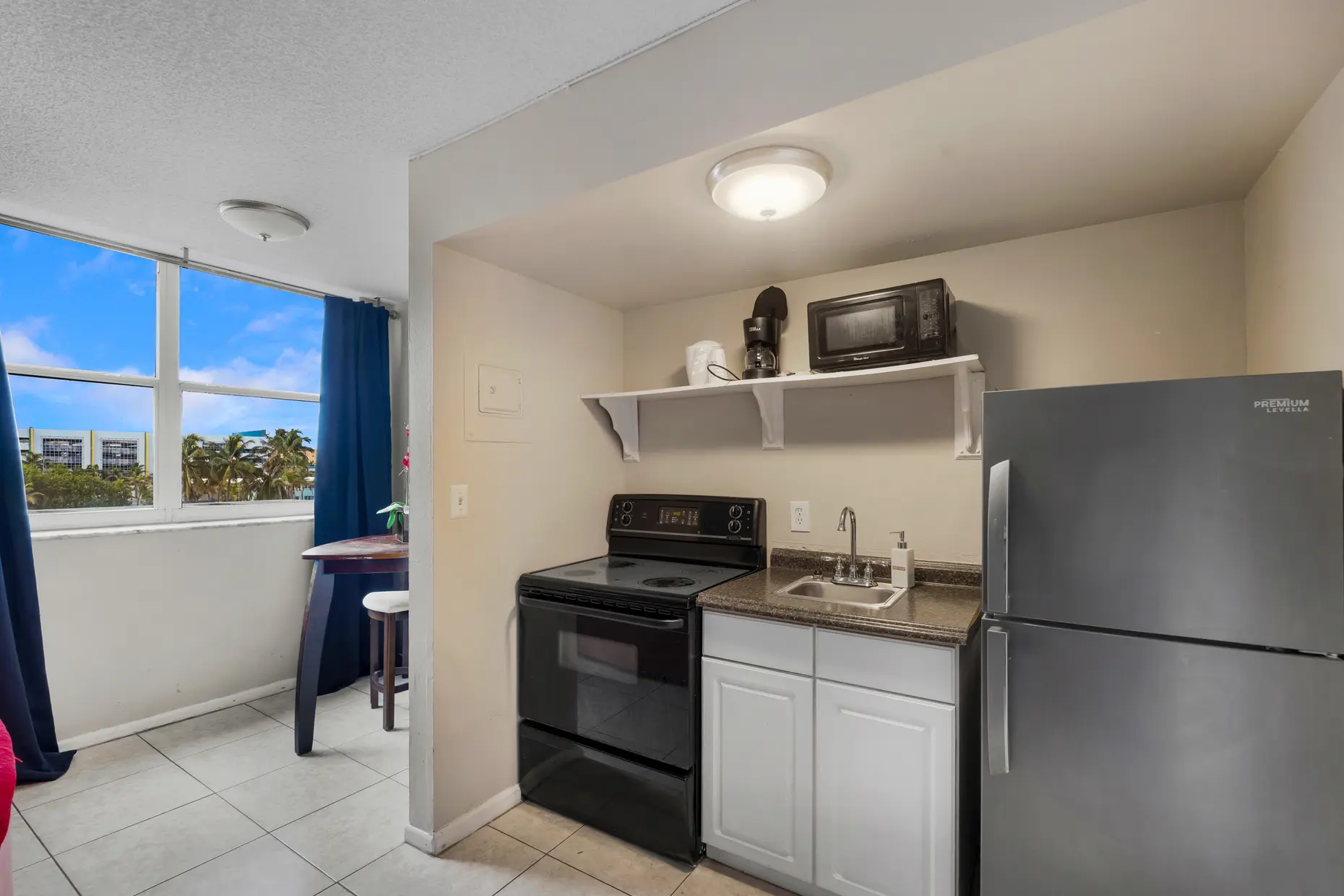 Studio suite kitchenette with stove and full-size fridge